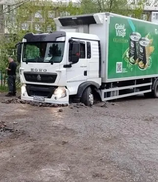 На улице Коммунальная грузовой автомобиль ушёл передними колёсами в провал грунта между домами. Рабочие оградили место, администрация направила технику для восстановления покрытия.
