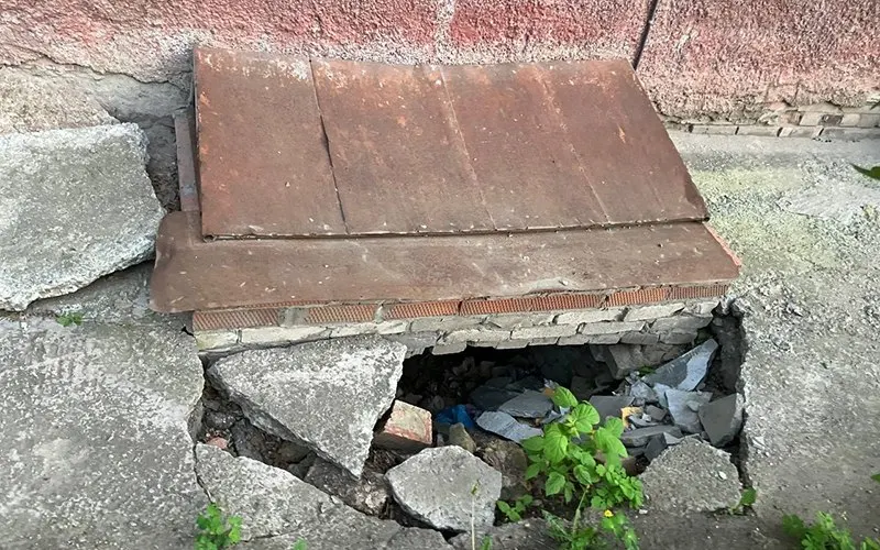 В нескольких местах вокруг муниципального детского сада №24 образовались провалы в отмостке, образовавшие пустоты, ведущие в подвал; на месте видны обломки и лишь одна сигнальная лента, следов ремонта нет.