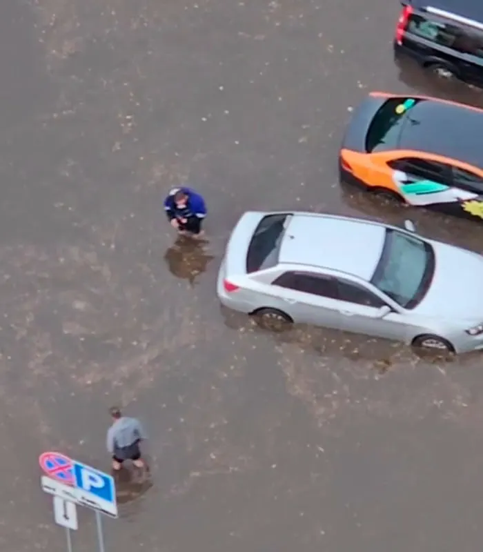 Мощный дождь затопил часть города — в отдельных районах вода достигает уровня по колено; на одном видео курьер на самокате преодолевает затопленную дорогу.