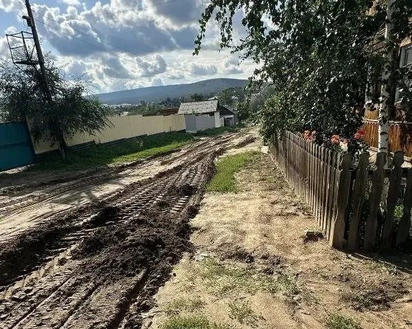 После проливных дождей дорога в городе Кяхта оказалась размытой, но горожане своими силами восстановили участок, привлекая технику и грунт.