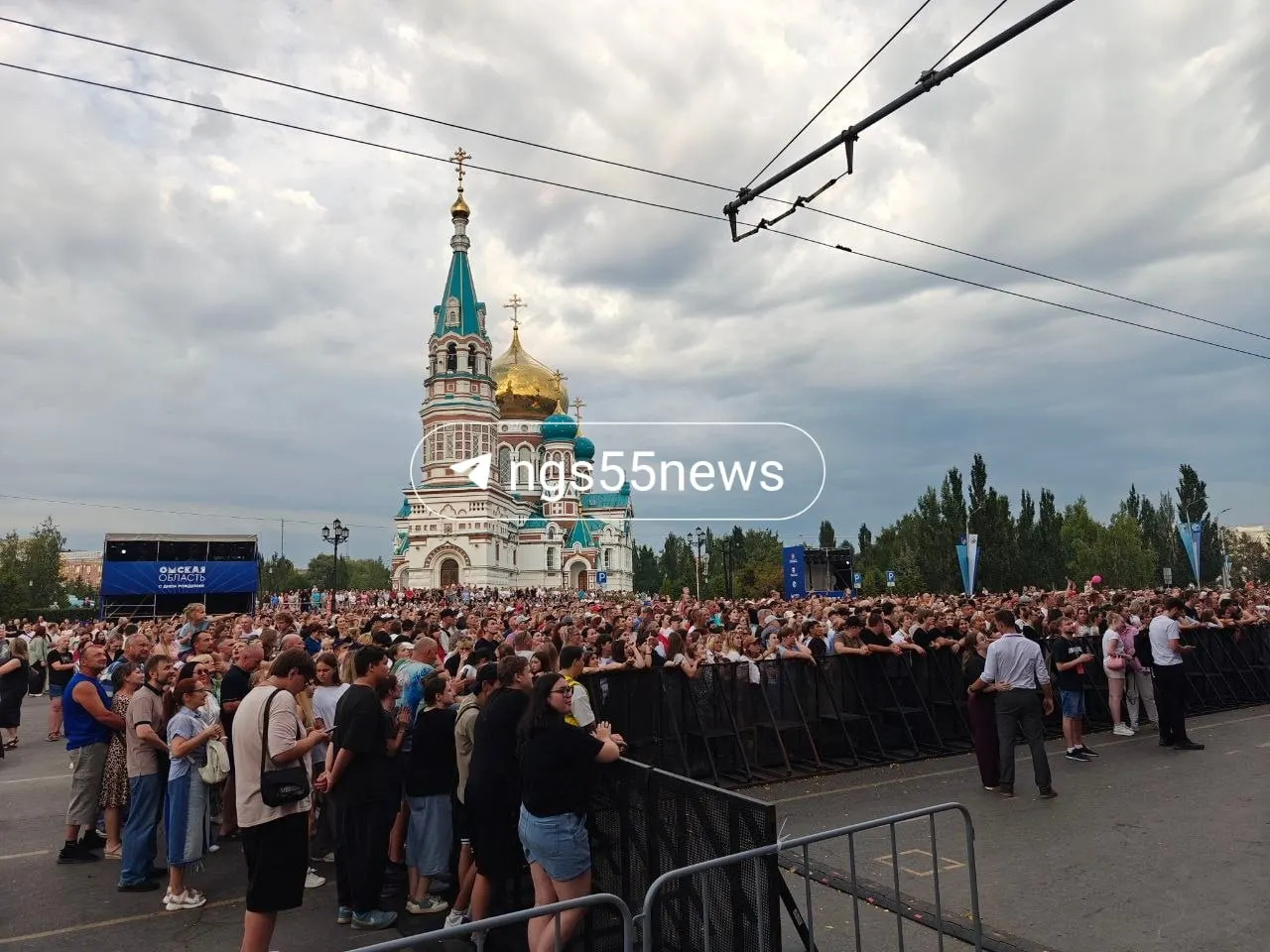 Зрители уже подтянулись к сцене: в ближайшие минуты выступят Андрей Державин и Ольга Серябкина. Пока диджей миксует треки, у сцены появляются первые плакаты.