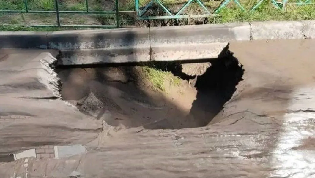 Из‑за прорыва водоснабжение заливает дорогу и тротуары; жители почти неделю обходятся по лужам, подвалы домов под угрозой затопления; работы ведутся одной подрядной организацией по очереди.